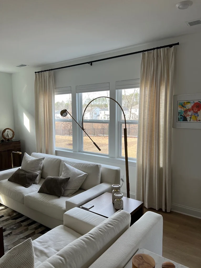 Living room with cream drapery panels